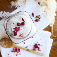 DIY Bath Salts for Muscle Relief and Relaxation (with Lavender & Epsom Salt) Glass jar filled with lavender rose bath salts topped with dried rose petals