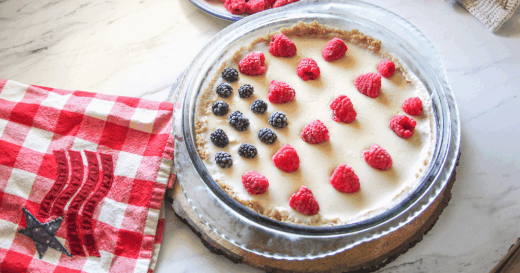 Close-up of fresh blackberries and raspberries on creamy 4th of July Pie