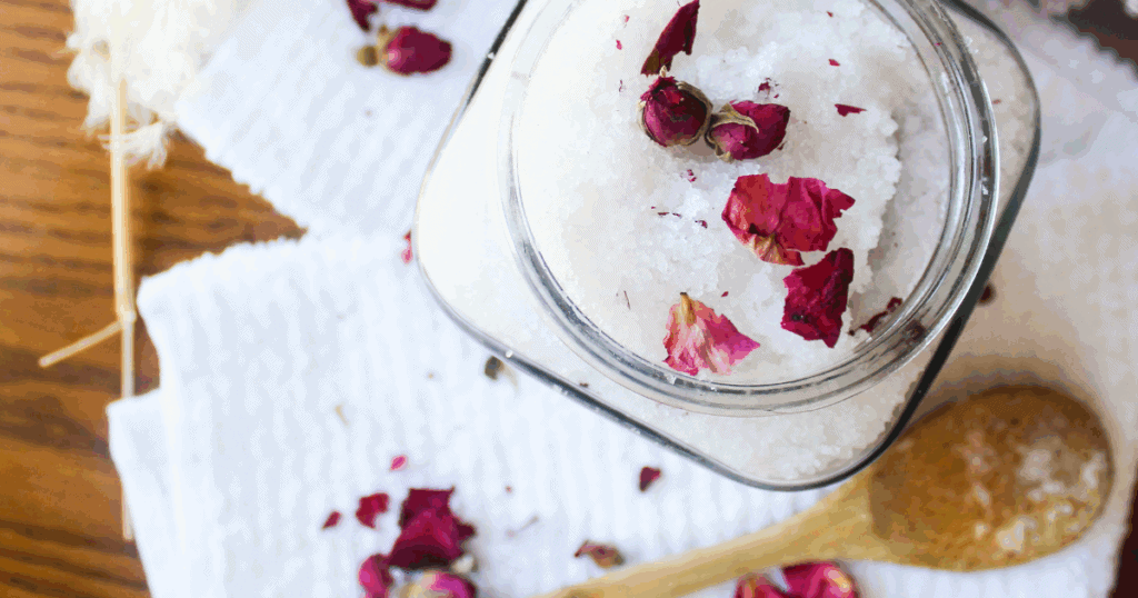 DIY Bath Salts for Muscle Relief and Relaxation (with Lavender & Epsom Salt) Glass jar filled with lavender bath salts topped with vibrant dried rose petals