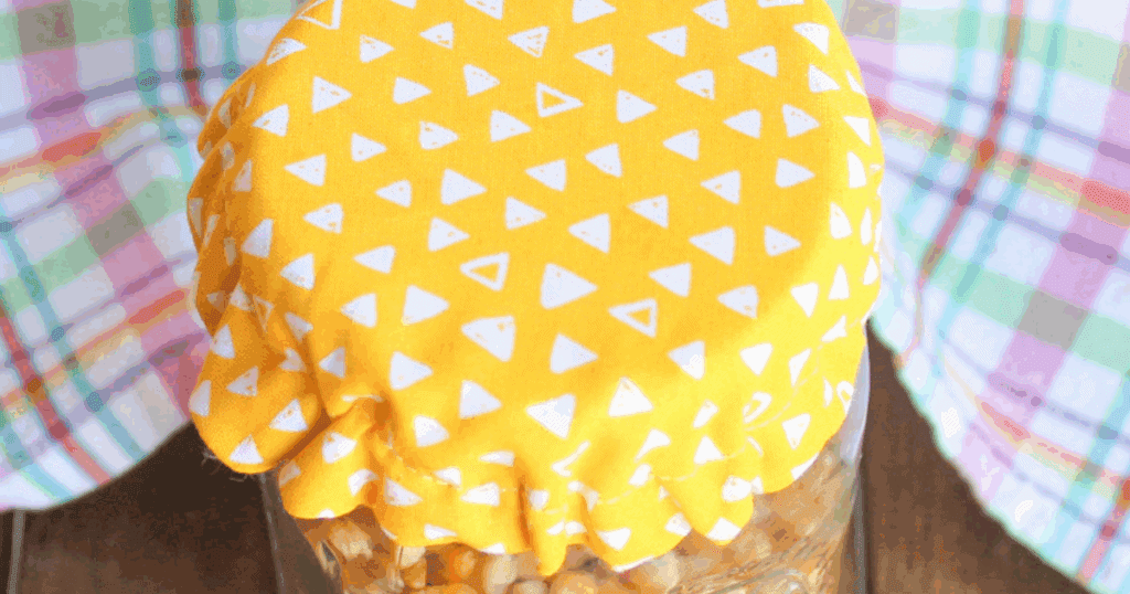 Close-up of DIY fabric jar cover with visible stitching and elastic gathered neatly around the lid.