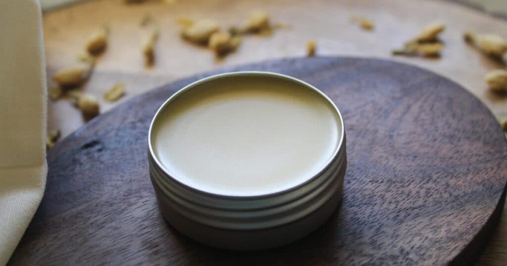 Close-up of smooth homemade tallow lip balm in a silver tin.