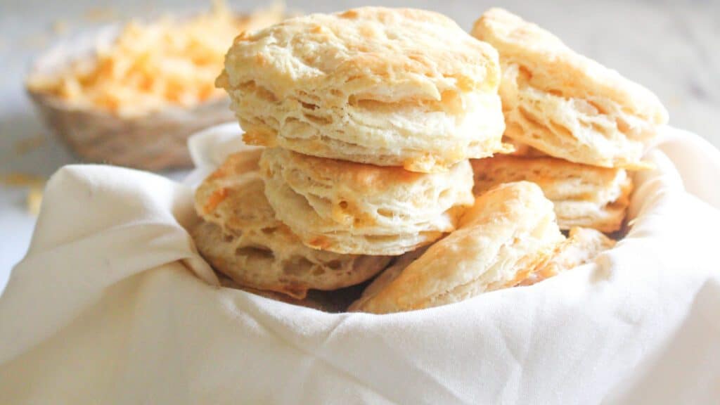Easy Cheddar Biscuits Close-up photo of a cheddar biscuit showing melted cheese and golden edges.