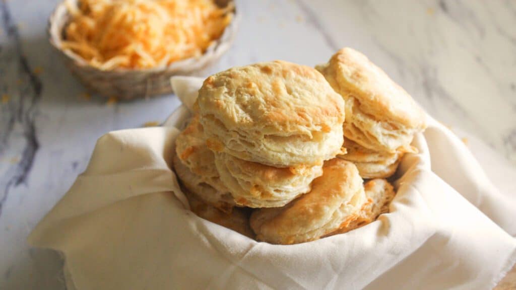 Easy Cheddar Biscuits Side view of golden cheddar biscuits stacked on a plate, ready to serve.