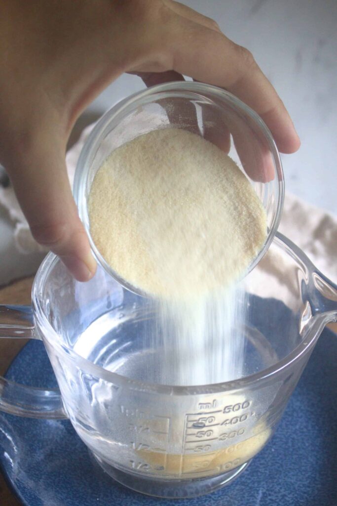 Pouring gelatin into water to bloom for homemade marshmallows without corn syrup