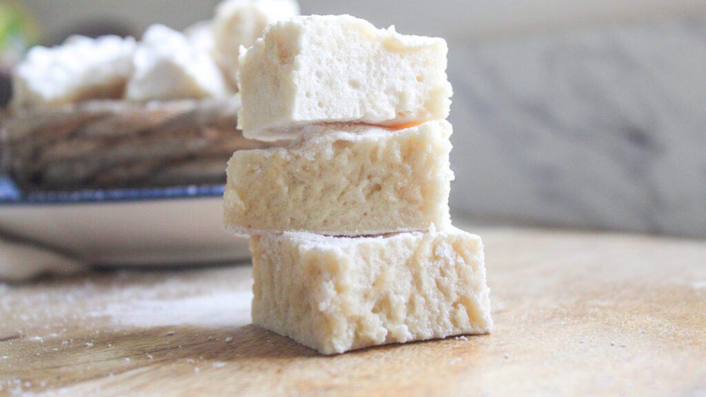 Close-up of homemade marshmallows cut into squares on a cutting board