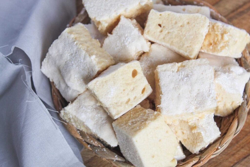 Homemade marshmallows made without corn syrup in a bowl on a cutting board