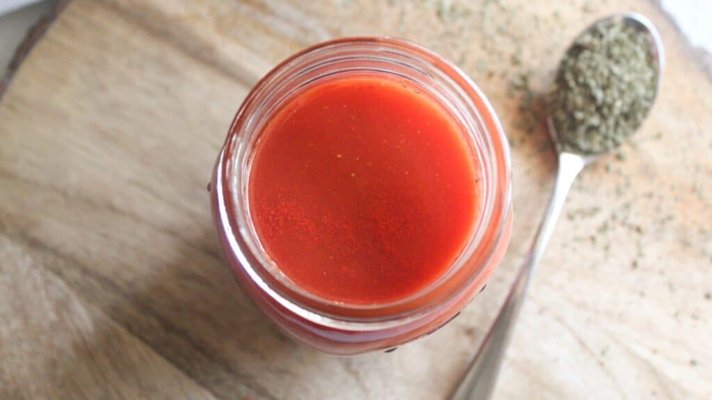 Close-up of fresh tomato sauce in a glass jar showing texture and color