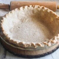 Golden, flaky lard pie crust baked in a round glass dish