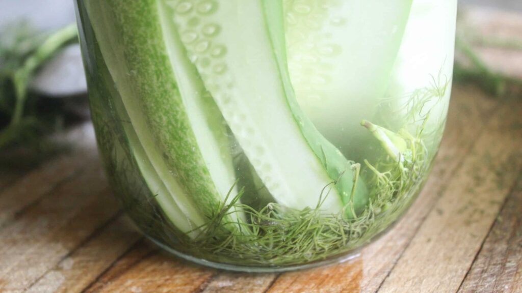 Homemade crunchy fermented pickles in a glass jar.
