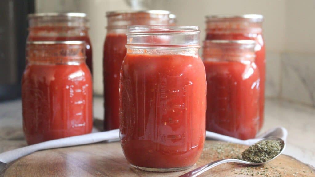Rustic tomato sauce in a glass jar on a wooden table with natural lighting