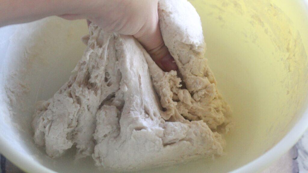 Same Day Sourdough Bread Mixing water into sourdough ingredients to form the dough.