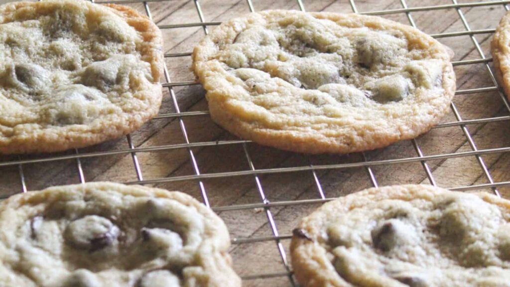 Freshly baked vintage chocolate chip cookies cooling on a wire rack.