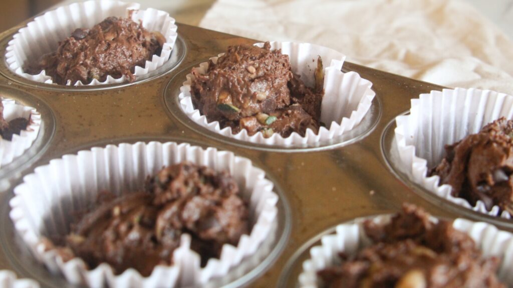 Chocolate Chip Zucchini Muffins Chocolate zucchini muffin batter scooped into a muffin tin