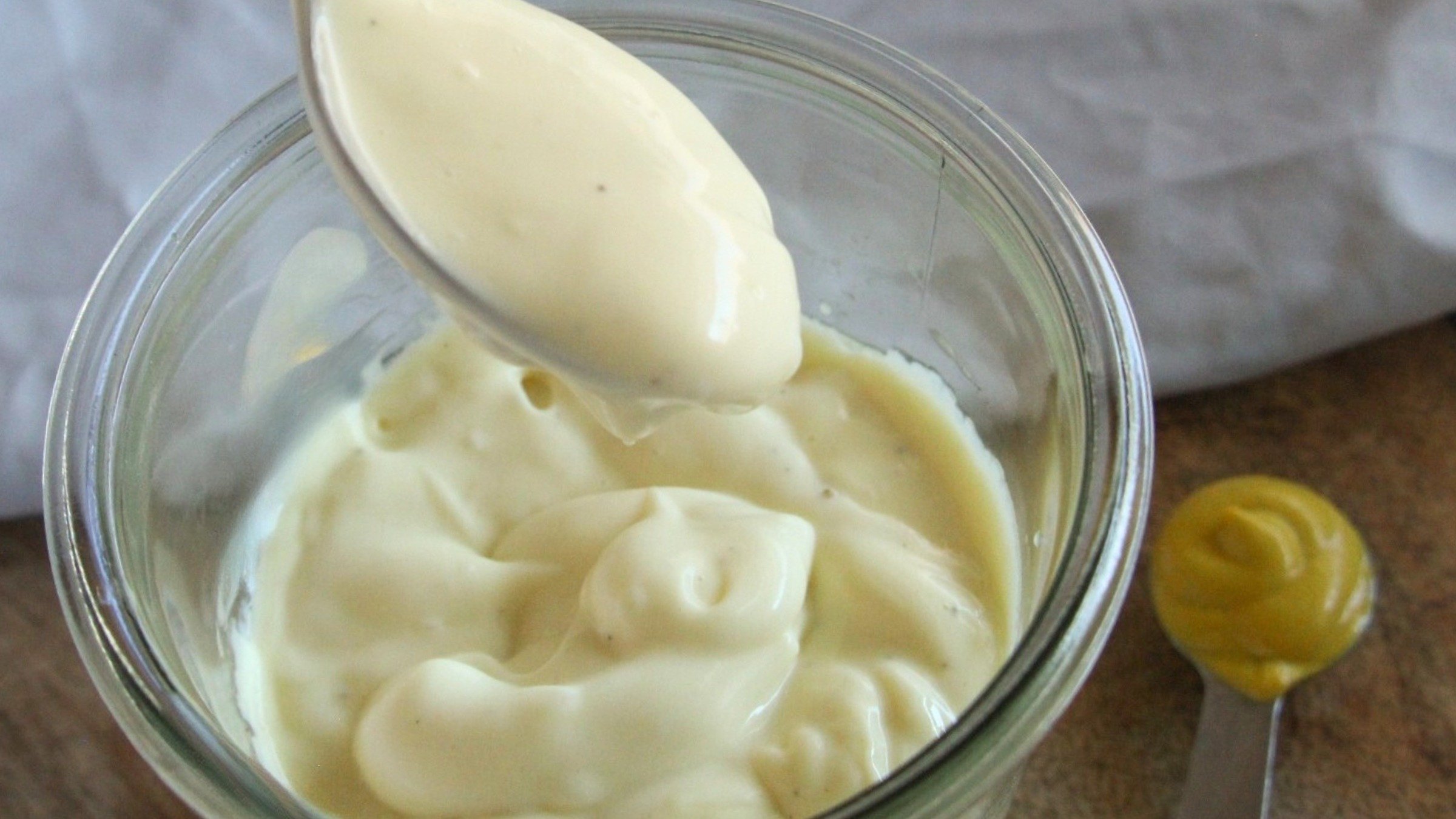 Homemade mayonnaise in a glass jar with a smooth, creamy texture