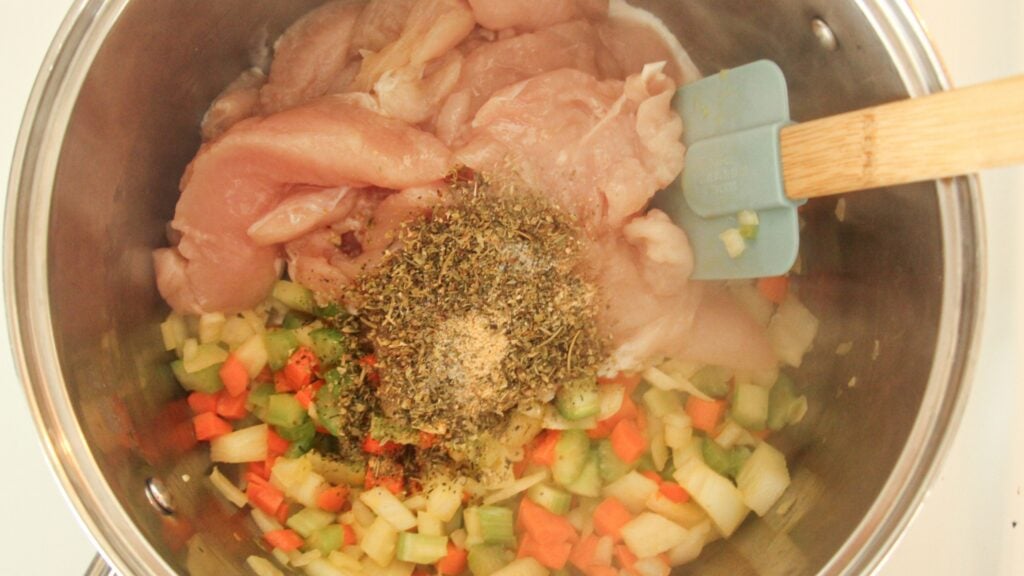 Raw chicken, vegetables, and broth in a pot ready to cook healthy chicken and dumplings