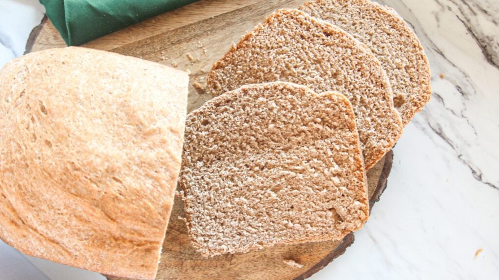 Half loaf of whole wheat bread with slices laying down