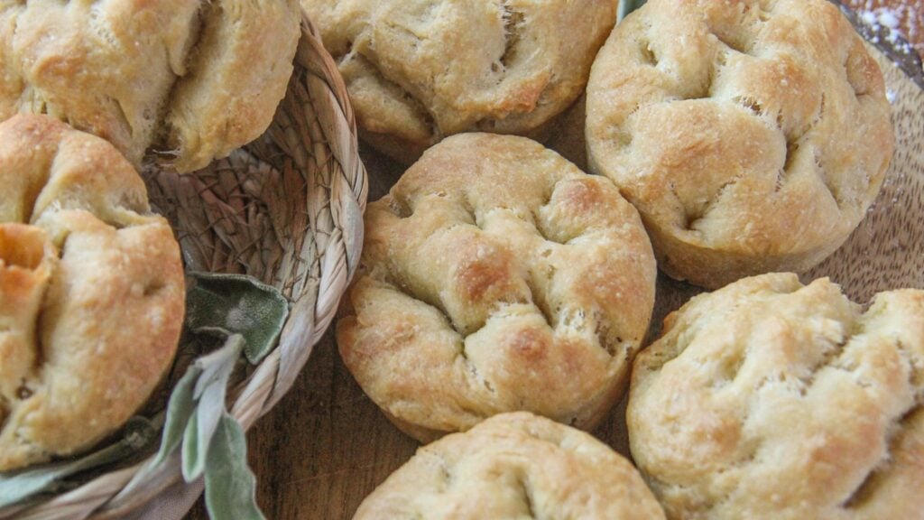 No-yeast focaccia muffins with fresh sage on a cutting board