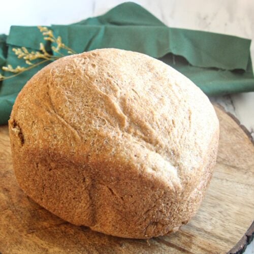 100% whole wheat bread machine loaf showing a golden brown crust and high rise.