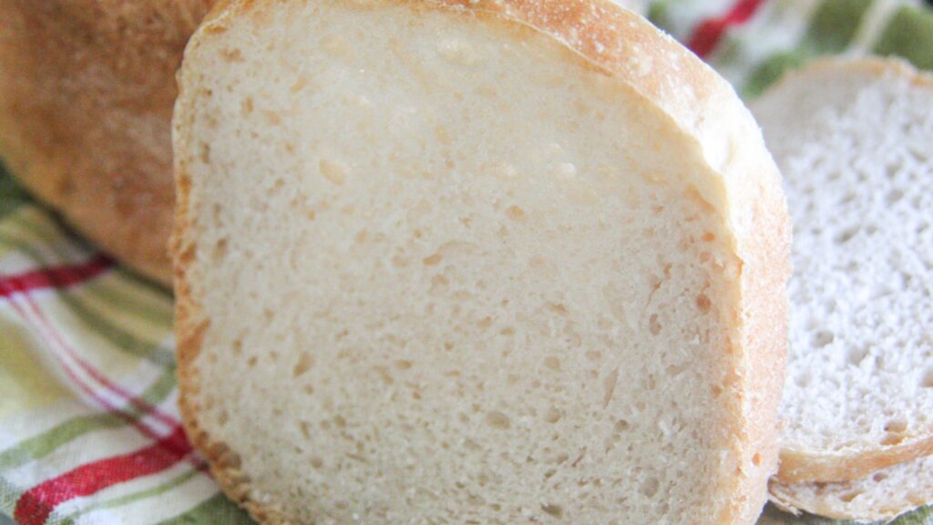 Extreme close-up of a slice of sourdough bread showing the fine, soft crumb and light golden crust.