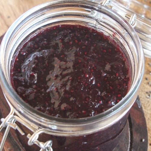 Easy 5-ingredient blueberry chia jam in a glass jar on a wooden board